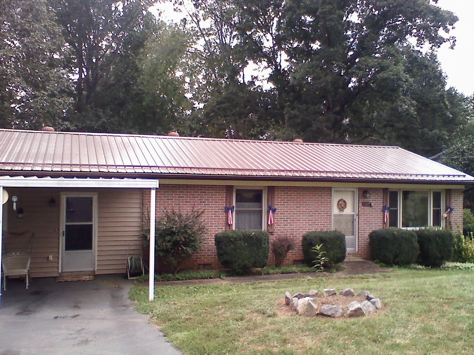 Bronze metal roof and carport on a brick ranch home — Roof Repair work by our crew in Valles Mines