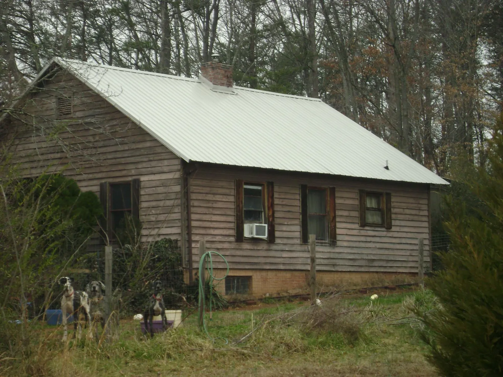 White metal roof on an old wood sided farmhouse, from a Metal Roof Installation job in Valles Mines
